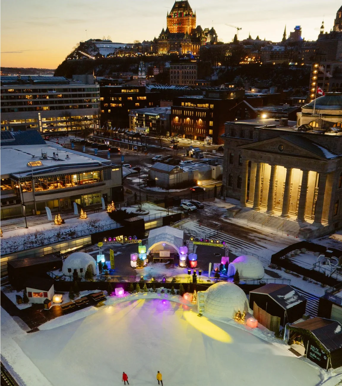 Aerial view of Discoglace illuminated skating rink in downtown Quebec City at dusk.