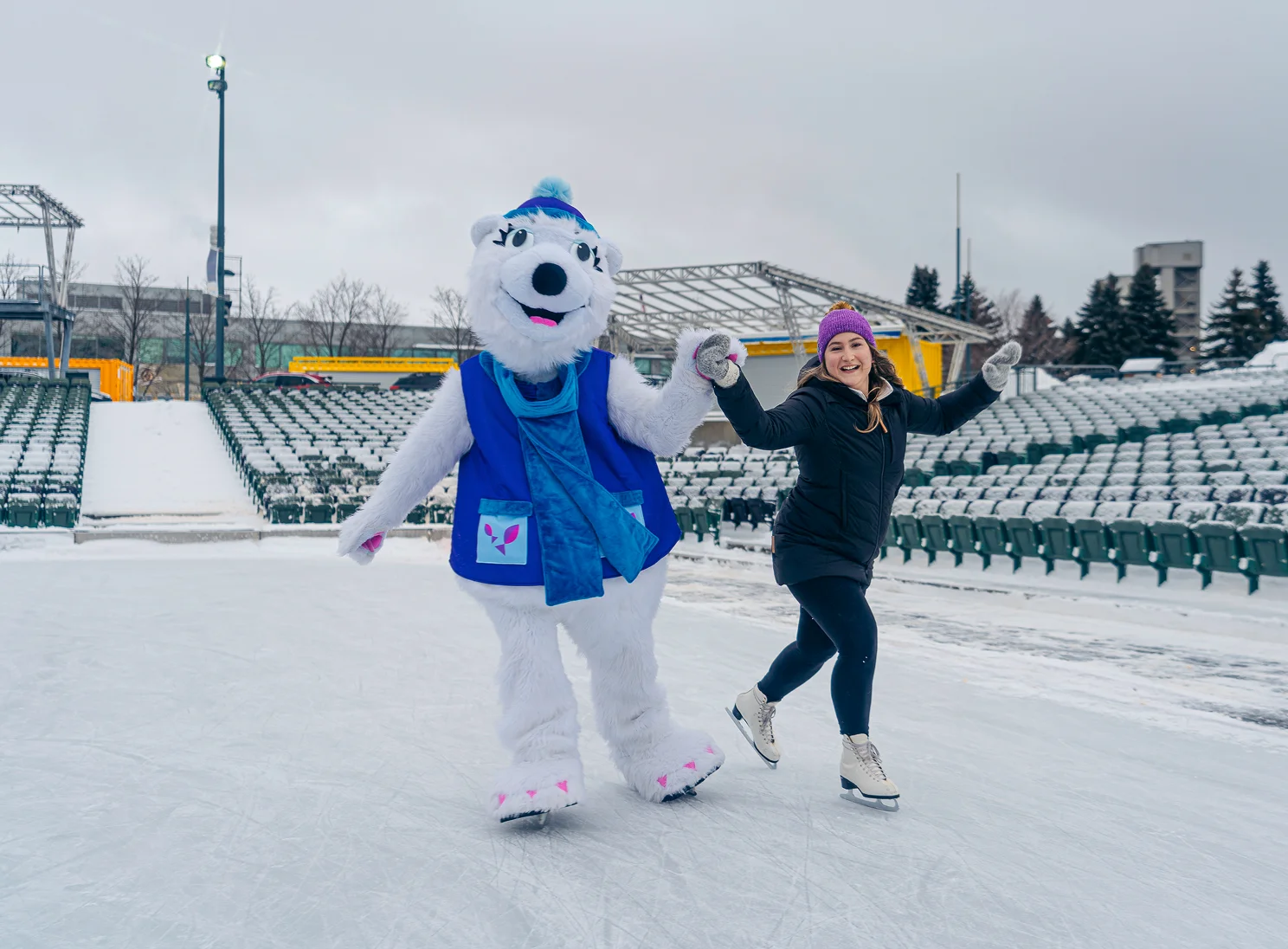 Women with a polar bear mascot on the ice rink.